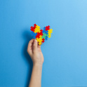 A hand holding a heart made of jigsaw pieces