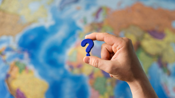 A question mark in front of a map of the world