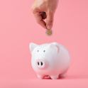 Putting a coin into a piggy bank