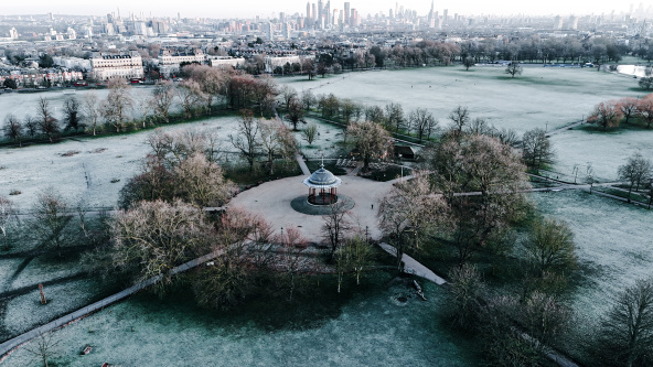And aerial view of the bandstand on a frosty Clapham Common. With the skyscrapers of the City of London in the background