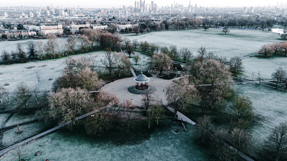 And aerial view of the bandstand on a frosty Clapham Common. With the skyscrapers of the City of London in the background