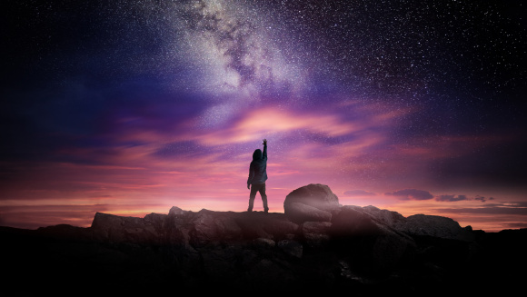 The night landscape and milky way with a teen reaching for the stars