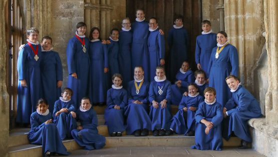 Choristers of Wells Cathedral pose for a relaxed group photograph in a cathedral cloister